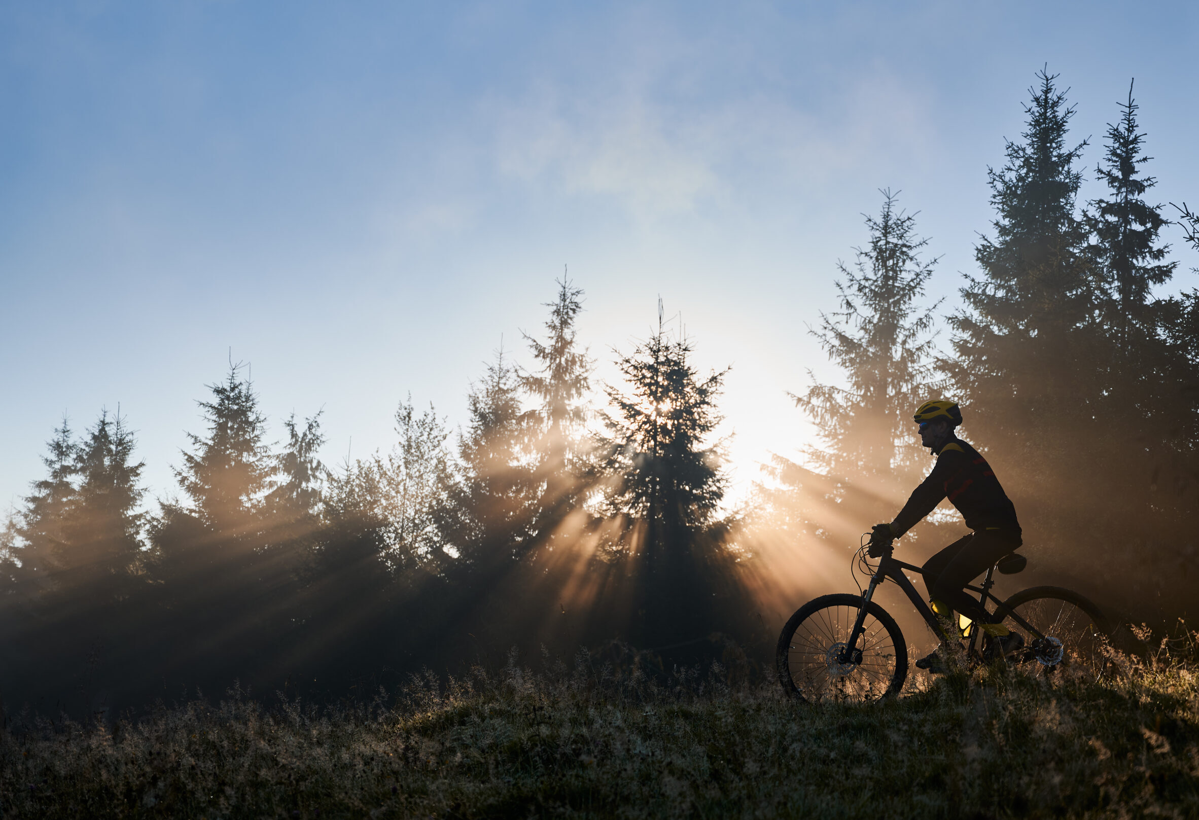 young man riding bicycle in the mountains in early morning